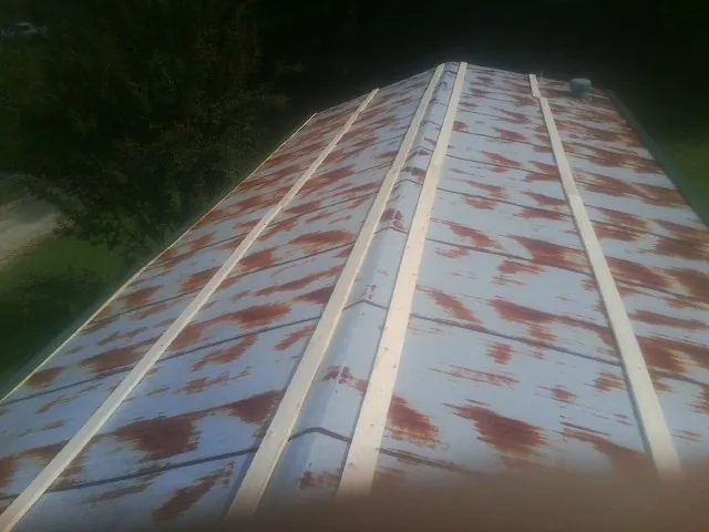 Rusted metal roof panels with new wood purlins before replacement — Storm Damage Roof Repair in Ozawkie by Roofing Brothers
