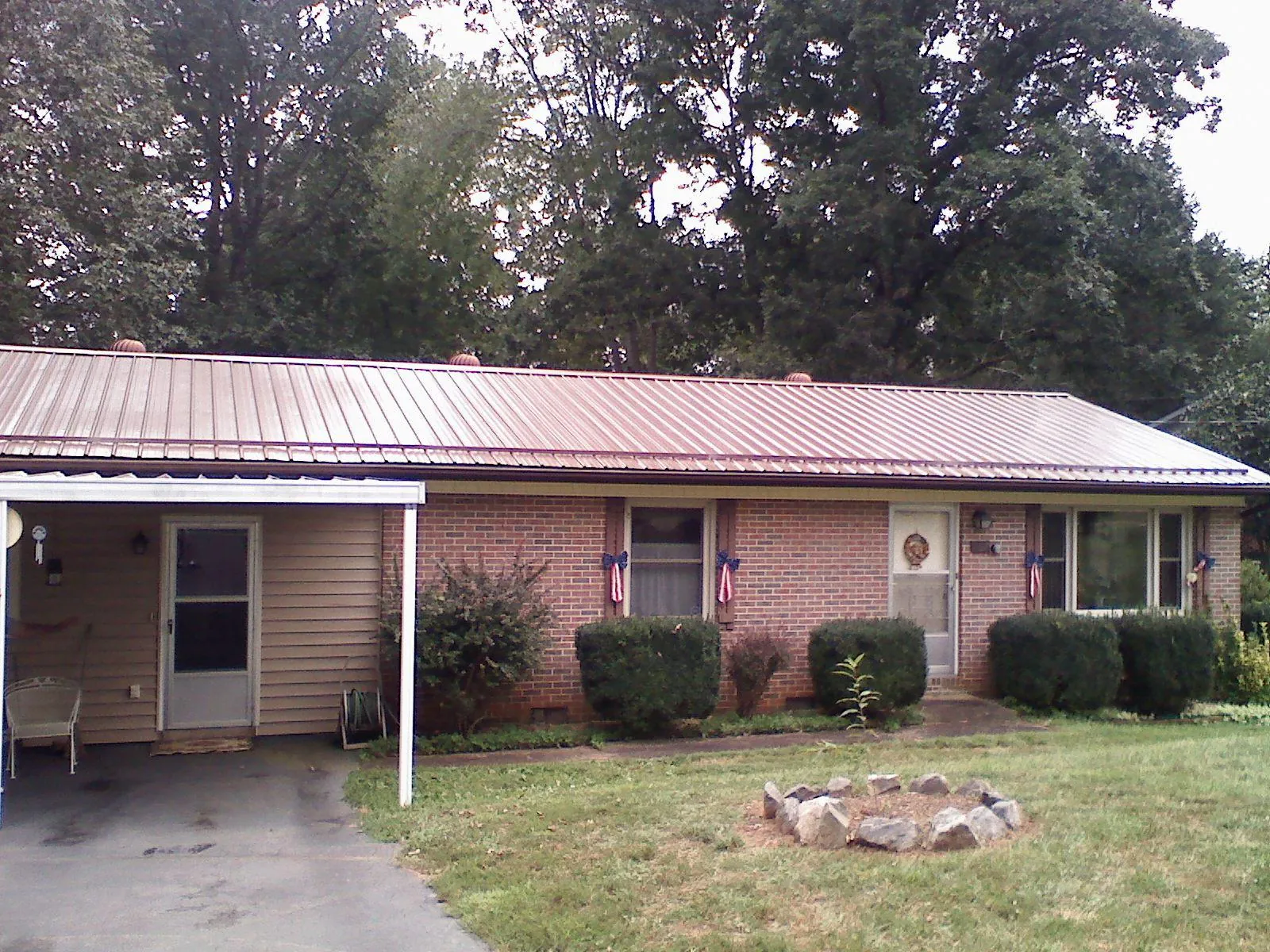 Bronze metal roof and carport on a brick ranch home — Roof Repair work by our crew in Ozawkie