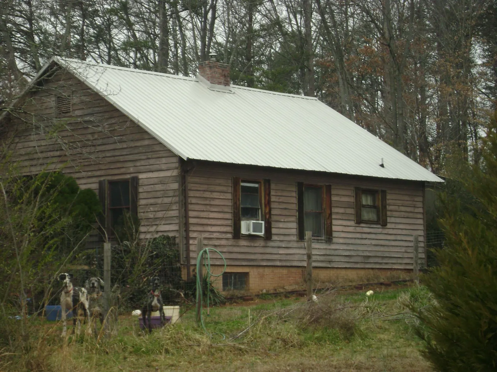 White metal roof on an old wood sided farmhouse, from a Metal Roof Installation job in Ozawkie